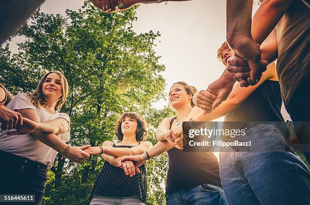 friends holding hands in the park - girls holding hands stock pictures, royalty-free photos & images