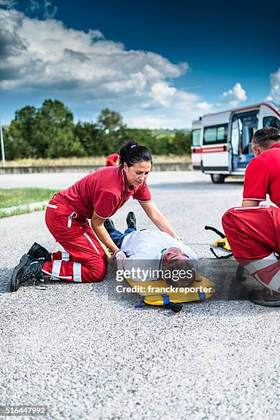 rescue team helping injured man - gory car accident fotos stockfoto's en -beelden