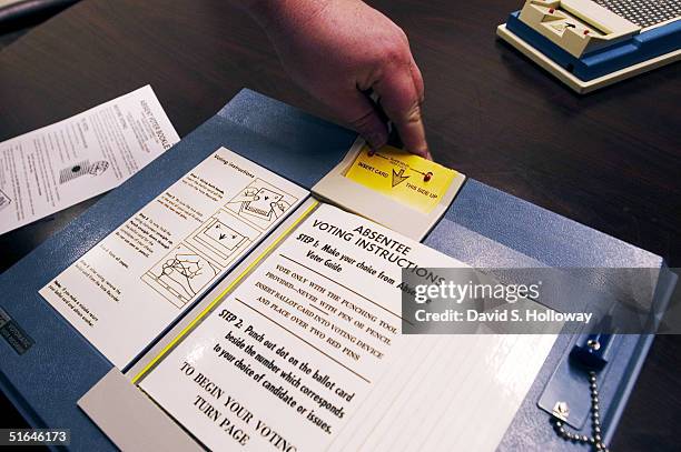 Matt Damschroder, director of the Franklin County Board of Elections, demonstrates the punch card ballots used for early voting at the Franklin...