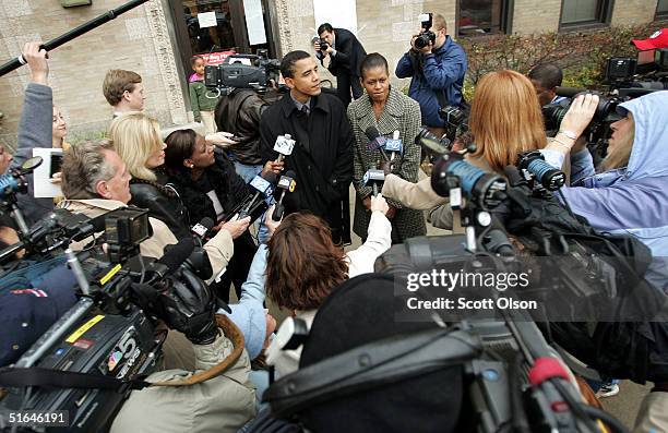 Candidate for the U.S. Senate Barack Obama speaks to news reporters, with his wife Michelle at his side, outside his polling place after voting...