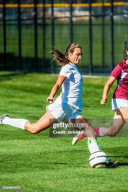 female soccer player in white preps for power kick - aggression school stock pictures, royalty-free photos & images