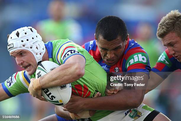 Jarrod Croker of the Raiders is tackled by the Knights defence during the round three NRL match between the Newcastle Knights and the Canberra...