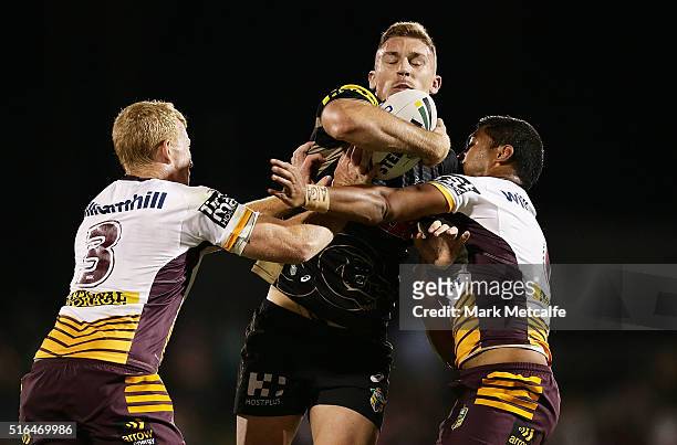 Bryce Cartwright of the Panthers is tackled by Jack Reed and Anthony Milford of the Broncos during the round three NRL match between the Penrith...