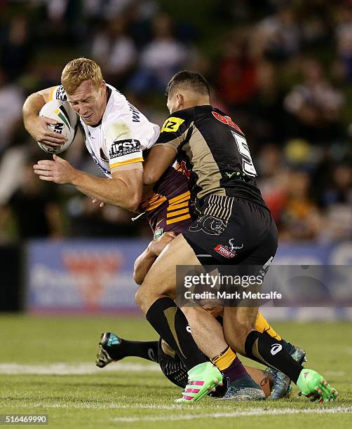 Jack Reed of the Broncos is tackled by Dallin Watene-Zelezniak of the Panthers during the round three NRL match between the Penrith Panthers and the...