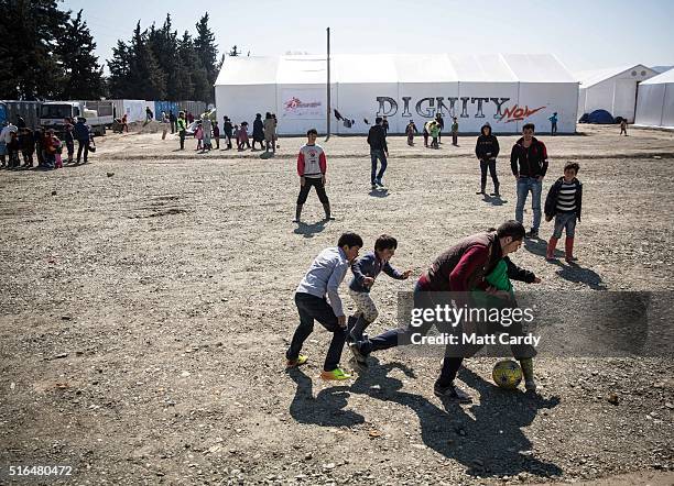 Children play football at the Idomeni refugee camp on the Greek Macedonia border on March 19, 2016 in Idomeni, Greece. Thousands of migrants remain...