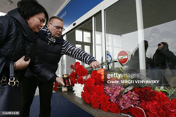 People lay flowers at the airport entrance in Rostov-on-Don on March 19, 2016. A flydubai passenger jet crashed in southern Russia early Saturday,...