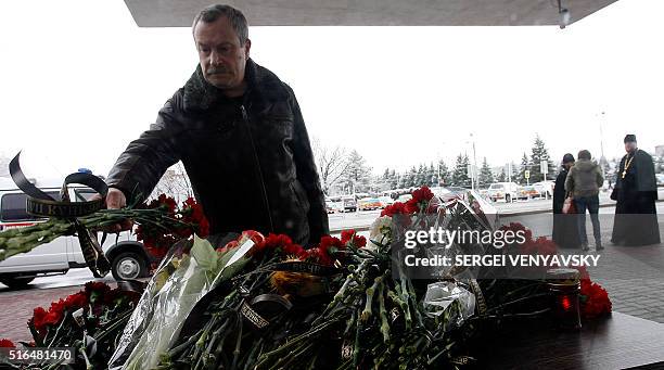 Man lays flowers at the airport entrance in Rostov-on-Don on March 19, 2016. A flydubai passenger jet crashed in southern Russia early Saturday,...