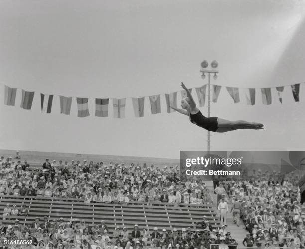 Bill Carr of the United States breaks the tape to win the first heat of the 400 meter event during the Los Angeles Olympic Games. Wilson of Canada is...