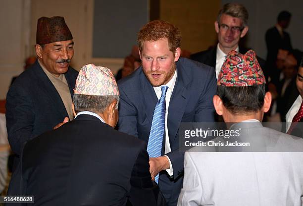 Prince Harry chats to men in traditional nepalese hats during a welcome reception at the Yak and Yeti Hotel on day one of his visit to Nepal on March...