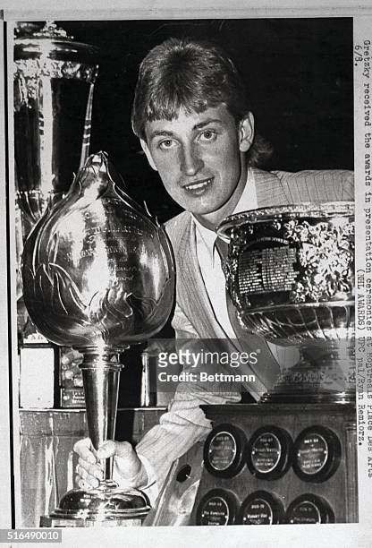 Wayne Gretzky of the Edmonton Oilers poses with the Hart Trophy as the National Hockey League's Most Valuable Player, marking the first time in...
