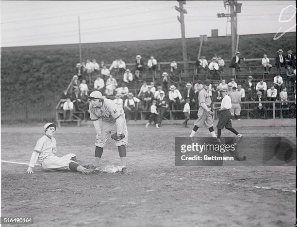 Mary Schull, left fielder on the Girls Team, practicing a slide into first, while Mary Gilroy, stands guard over the initial sack.