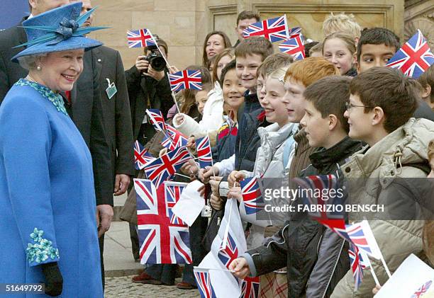 Britain's Queen Elizabeth II looks at pupils of Berlin's Charles-Dickens elementary school after her visit to the Alte National Gallery of fine art...
