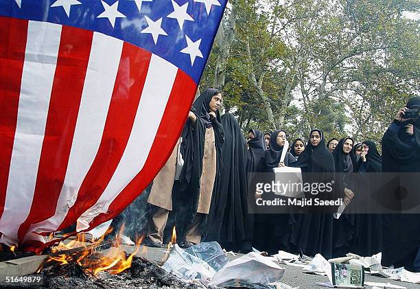 Iranian women burn a U.S. Flag outside the former U.S. Embassy at a gathering to mark the 25th anniversary of the seizure of the U.S. Embassy on...