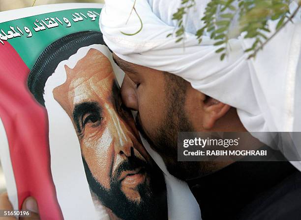 An Emirati man kisses the picture of Sheikh Zayed bin Sultan al-Nahayan during the Sheikh's funeral in Abu Dhabi 03 November 2004. Nahayan, the...