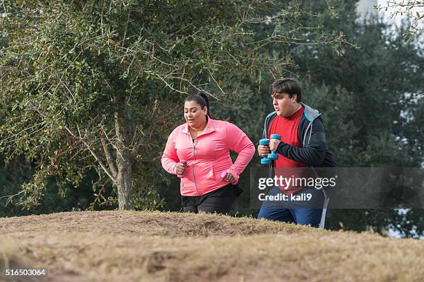 overweight people exercising, running with dumbbells - fat couple stock pictures, royalty-free photos & images