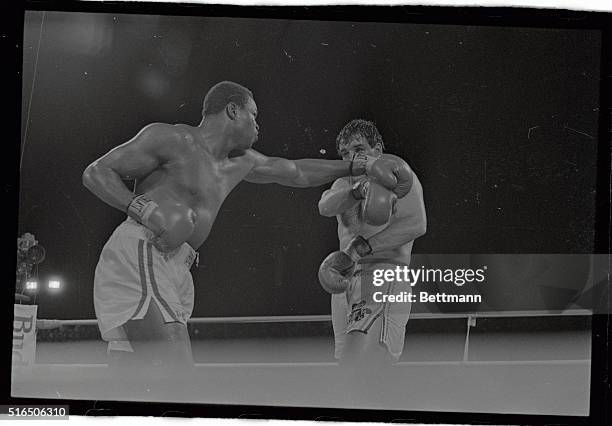 Droplets of water flying from his head, Gerry Cooney shows the effect of a right hook by WBC heavyweight champ Larry Holmes, during their 15-round...