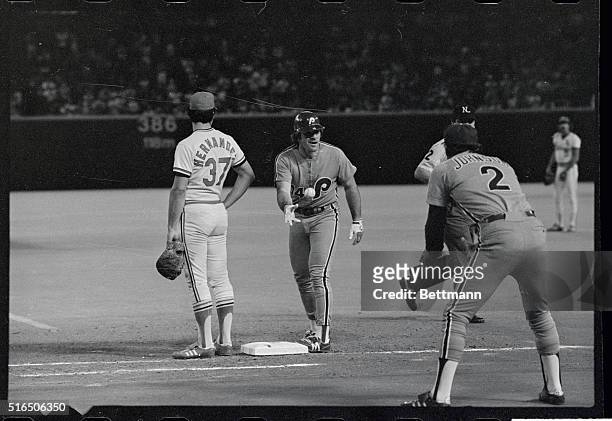Happy Philadelphia Phillies' Pete Rose tosses the ball to base coach Deron Johnson after tying Hank Aaron all time hits of 3,771 in the sixth inning...