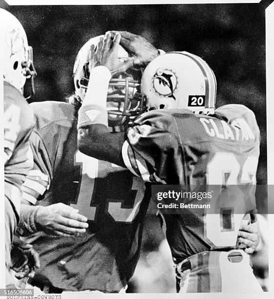 After catching the pass thrown by Miami Dolphin quarterback Dan Marino, left, and running in for the game-winning touchdown, Dolphin wide receiver...