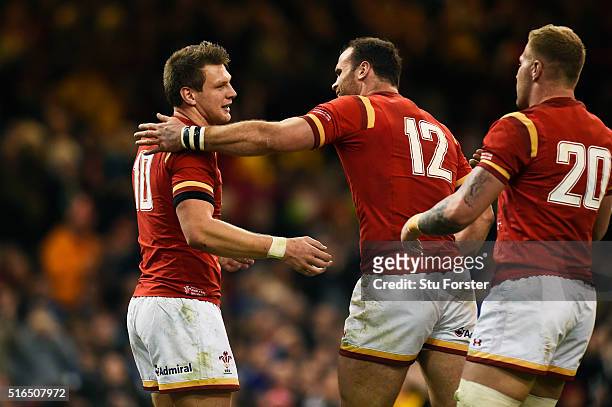Dan Biggar of Wales is congratulated by teammate Jamie Roberts and Ross Moriarty after scoring his team's second try during the RBS Six Nations match...