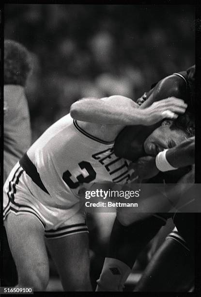 Unidentified 76er holds Celtics' Larry Bird in a headlock during a fight in the third quarter at Boston Garden.