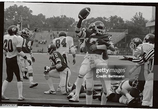 Northwestern Wildcat Ricky Edwards holds aloft a bell after scoring a touchdown in the first half of the game on September 25th, in this photograph....