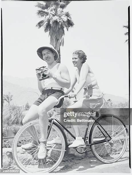 Starr photographer...Leah Ray, popular radio singer, pilots Jimmy Starr, well-known coast movie columnist, around the El Mirador hotel for subjects...