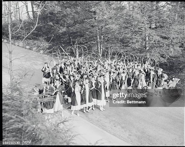 Wellesley Holds Annual May Day exercises at Wellesley College, at Wellesley, Mass., is the hoop-rolling race among seniors in caps and gowns. The...