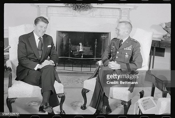 Washington: President Reagan meets with Gen. James L. Dozier in the Oval Office after attending the National Prayer Breakfast at the Washington...