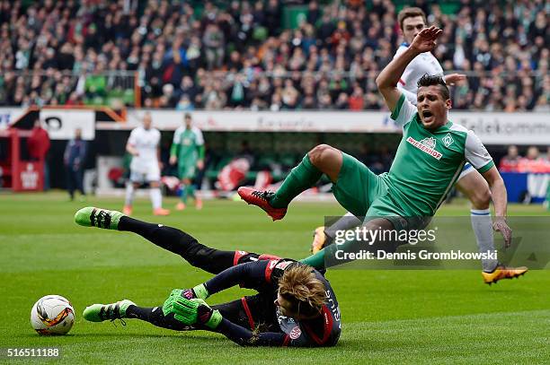 Zlatko Junuzovic of Werder Bremen is challenged by Loris Karius of 1. FSV Mainz 05 during the Bundesliga match between Werder Bremen and 1. FSV Mainz...