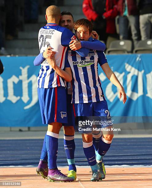 Genki Haraguchi of Berlin jubilates with team mate Vedad Ibisevic and John Anthony Brooks after scoring the first goal during the Bundesliga match...