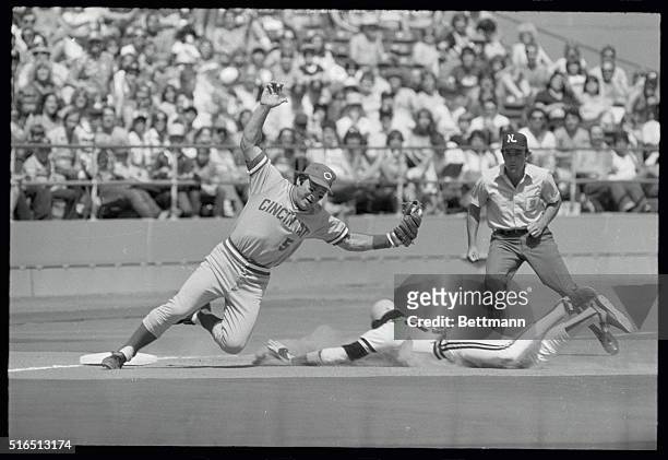 Red's Johnny Bench is pulled off bag as he snags throw from Alex Trevino as Pirates' Omar Moreno steals third in third inning of game.