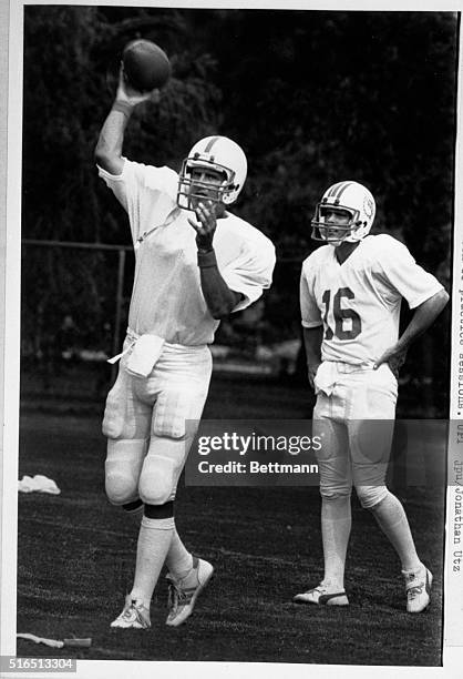 Miami Dolphin first round draft choice, Dan Marino, , throws a pass under the watchful eye of veteran quarterback David Wooley during a workout 7/14...