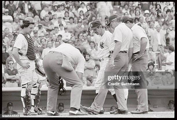 Umpire Tim McClelland measures the pine tar on Royals' George Brett's bat by using home plate as Yankees manager Billy Martin watches 7/24. The...
