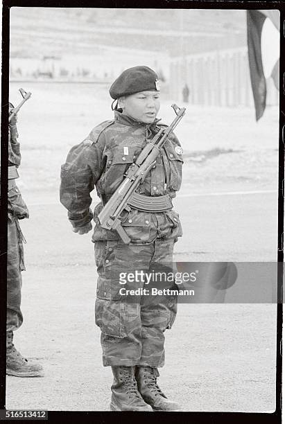 Young Palestinian guerilla with his AK-47 slung on his chest stands at attention as Yasser Arafat addresses PLO guerillas at this training camp 700...