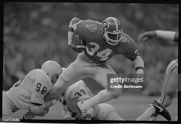 Georgia star tailback, Heisman Trophy winner Herschel Walker gets past Penn State's Ken Kelley and Dave Paffenroth on this second quarter Sugar Bowl...