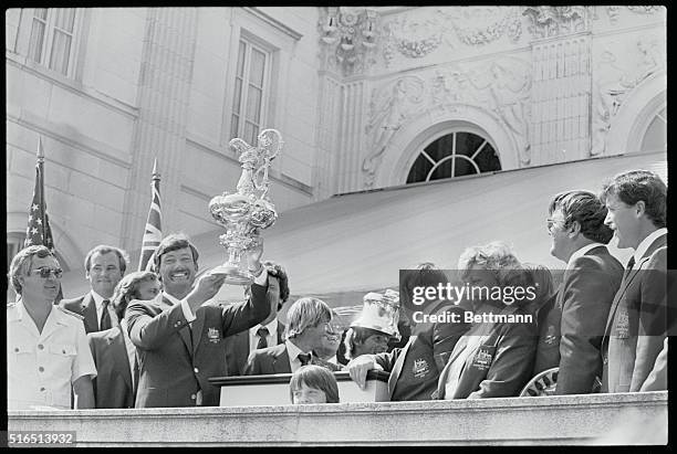 Proud John Bertrand, skipper of the Australia II, holds up the America's Cup after it was presented to him and his crew during ceremonies at...