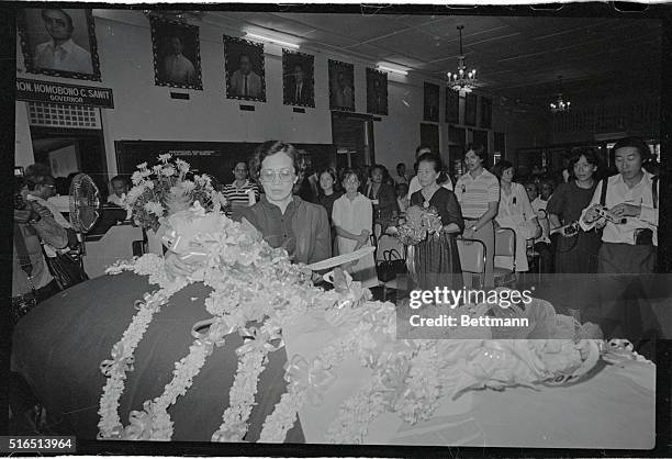 Mrs. Corazon Aquino places a bouquet of flowers on the casket of her husband, former Senator Benigno S. Aquino Jr., as his mother, Dona Aurora awaits...