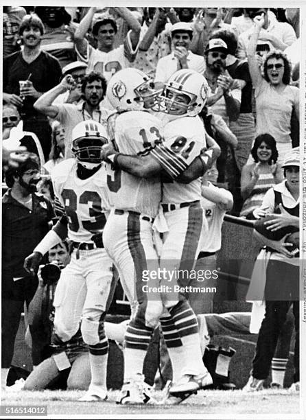 Dolphin quarterback Dan Marino puts a bear hug on receiver Jimmy Cefalo after the teamed up for the Dolphins second touchdown 12/29. Marino threw the...