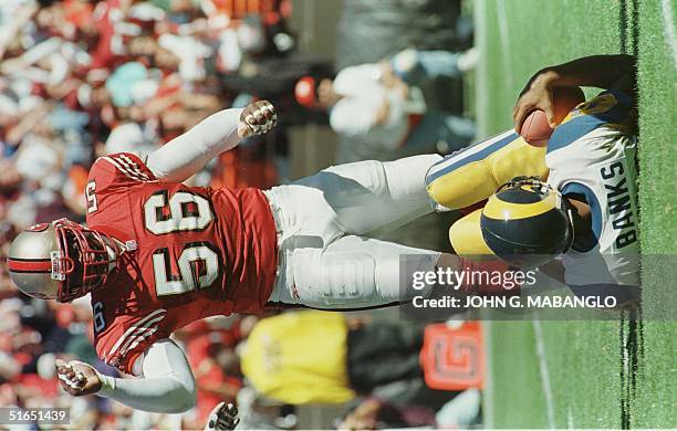 San Francisco 49ers defensive end Chris Doleman stands over St. Louis Rams quarterback Tony Banks after sacking Banks during their game 12 October in...