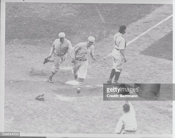 Cochrane and Simmons, catcher and outfielder of the Athletics, scoring in the ninth inning of the first game of the World Series, as result of Bing...