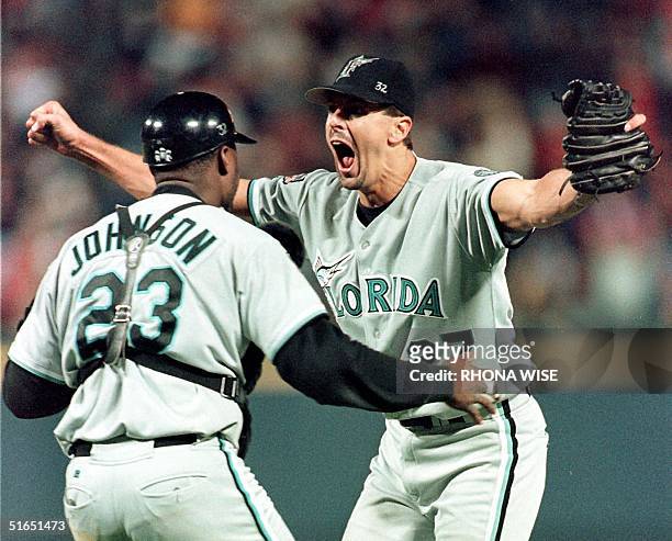 Pitcher Kevin Brown of the Florida Marlins runs to hug his catcher Charles Johnson after their team's 7-4 defeat of the Atlanta Braves 14 October in...