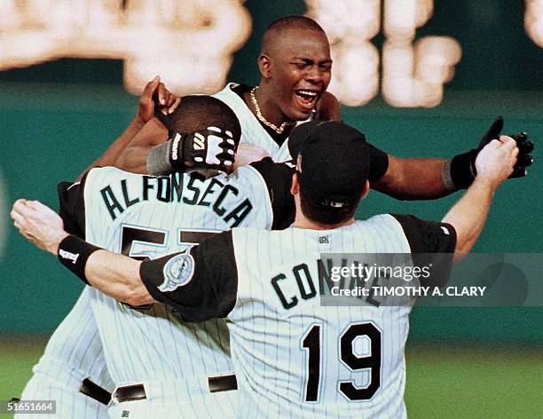 Florida Marlins player Edgar Renteria celebrates his game-winning hit against the Cleveland Indians with teammates Antionio Alfoseca and Jeff Conine...