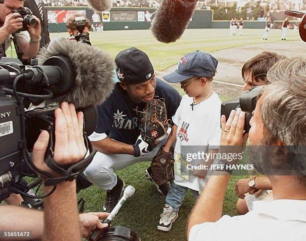 Seattle Mariners' player Ken Griffey Jr. Talks to Jonathan Lipnicki , the child star of the sports movie "Jerry Maguire," as the media surround them...