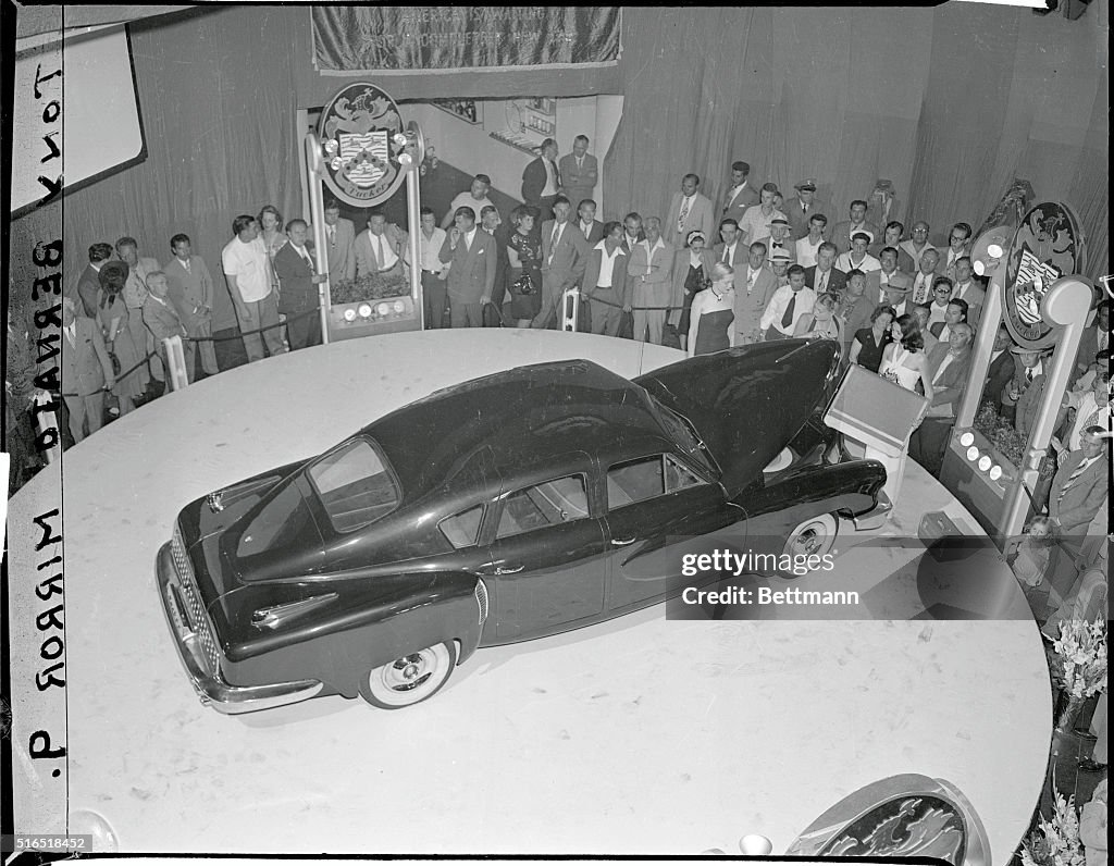 Models Placing Baggage into a Tucker Car