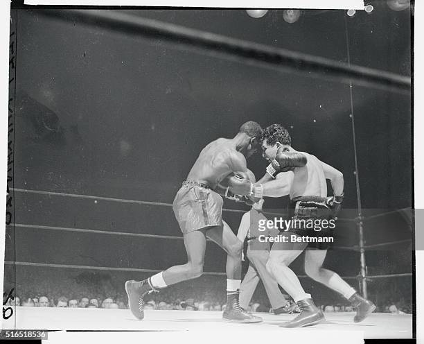 Jake LaMotta dark trunks and Tommy Bell are shown here fighting each other off.