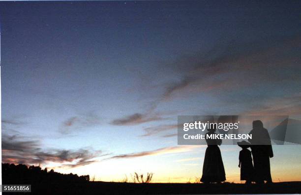 Mormon family is silhouetted against the sky as they take a stroll along the Bear River in Wyoming 13 July after setting up camp during their 4-month...