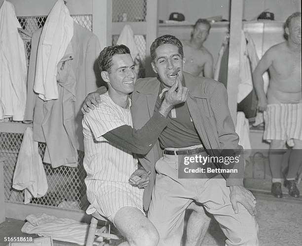 Bronx, New York: Yankee Stadium. Photo shows Yanks 2nd baseman Jerry Coleman lighting cigar fro Phil Rizzutto, Jerry's wife had a son early this...