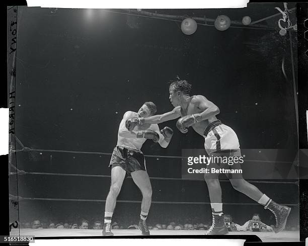 Manhattan, New York, New York: Former NBA welter champ Johnny Bratton scores with a right to Rocky Castellani's jaw in 6th frame of their 10 round go...