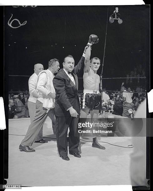 Manhattan, New York, New York: Carlos Ortiz stops Kenny Lane for junior welterweight championship. Photo shows announcer Johnny Addie holds up Carlos...