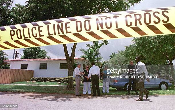 Miami Metro police officers stand 17 July in front of the house of a man who was shot dead inside his home in Miami Springs, FL. Authorities are...